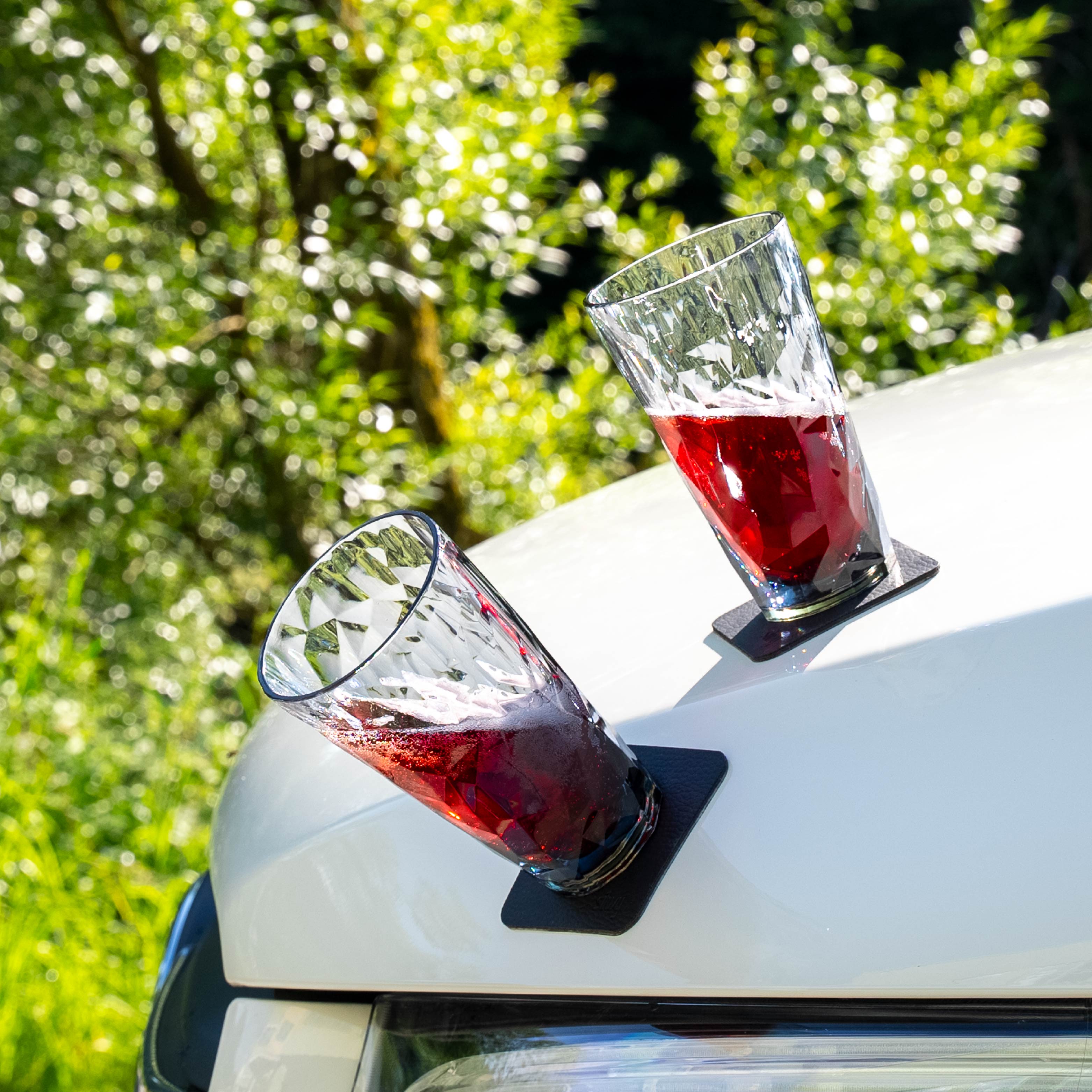 Magnet-Kunststoffgläser Longdrink abgestellt auf einer metallischen Motorhaube