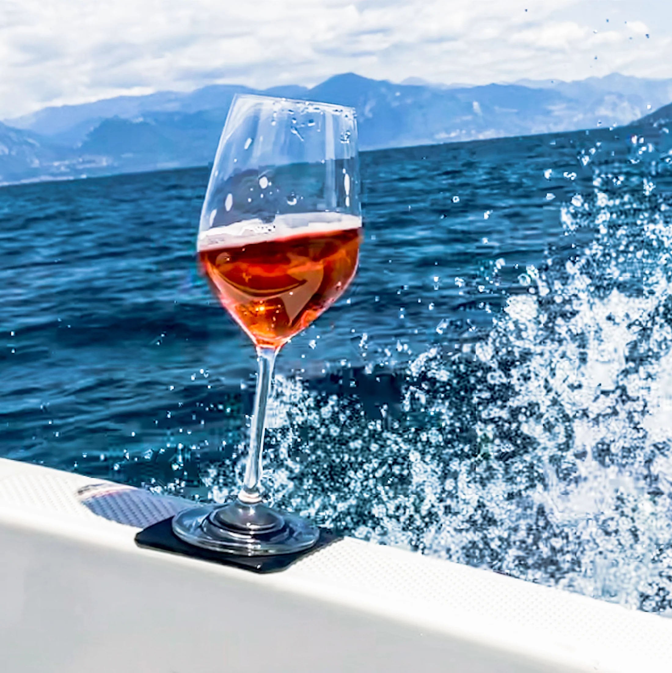 Magnet-Kristallglas Wein gefüllt mit Rosé mit dem quadratischen Metall-Nano-Gel-Pad auf einem Boot