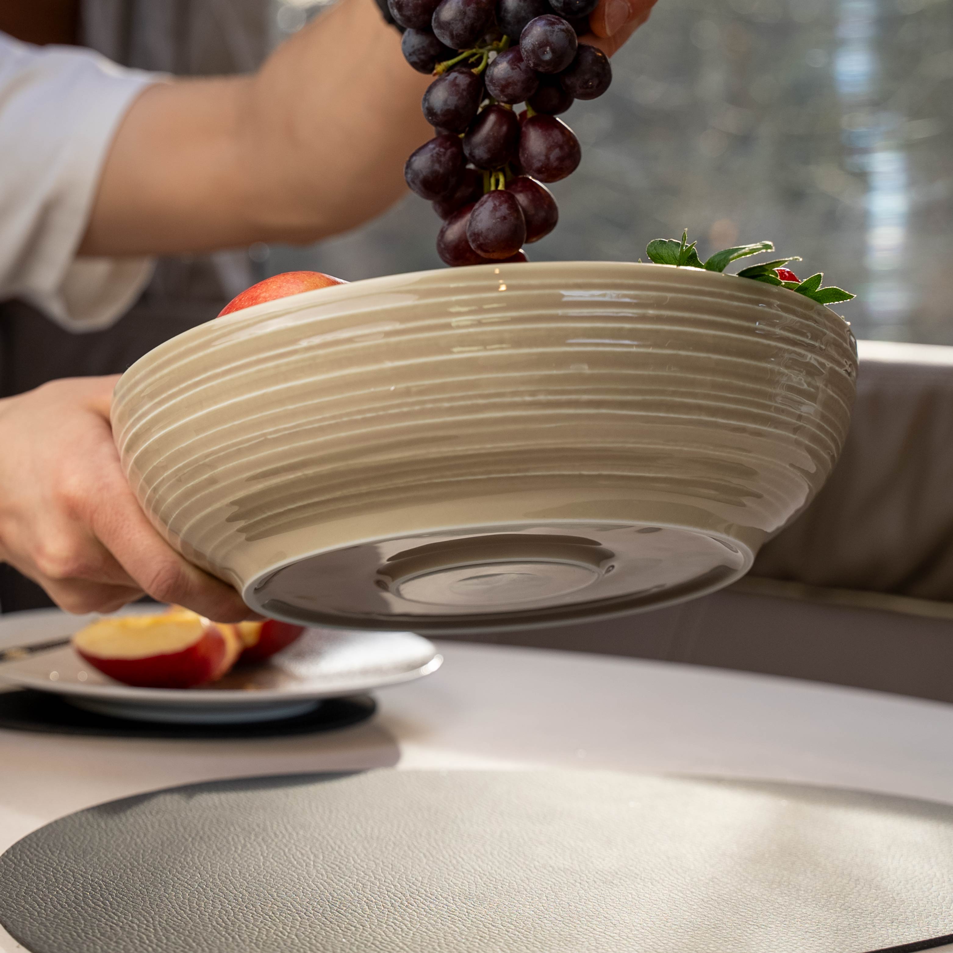 Magnet-Porzellan Food Bowl sand in der Luft gehalten und integriertem Magneten im Boden und Metall-Matte auf Tisch sowie gefüllt mit Weintrauben Äpfeln und Erdbeeren 