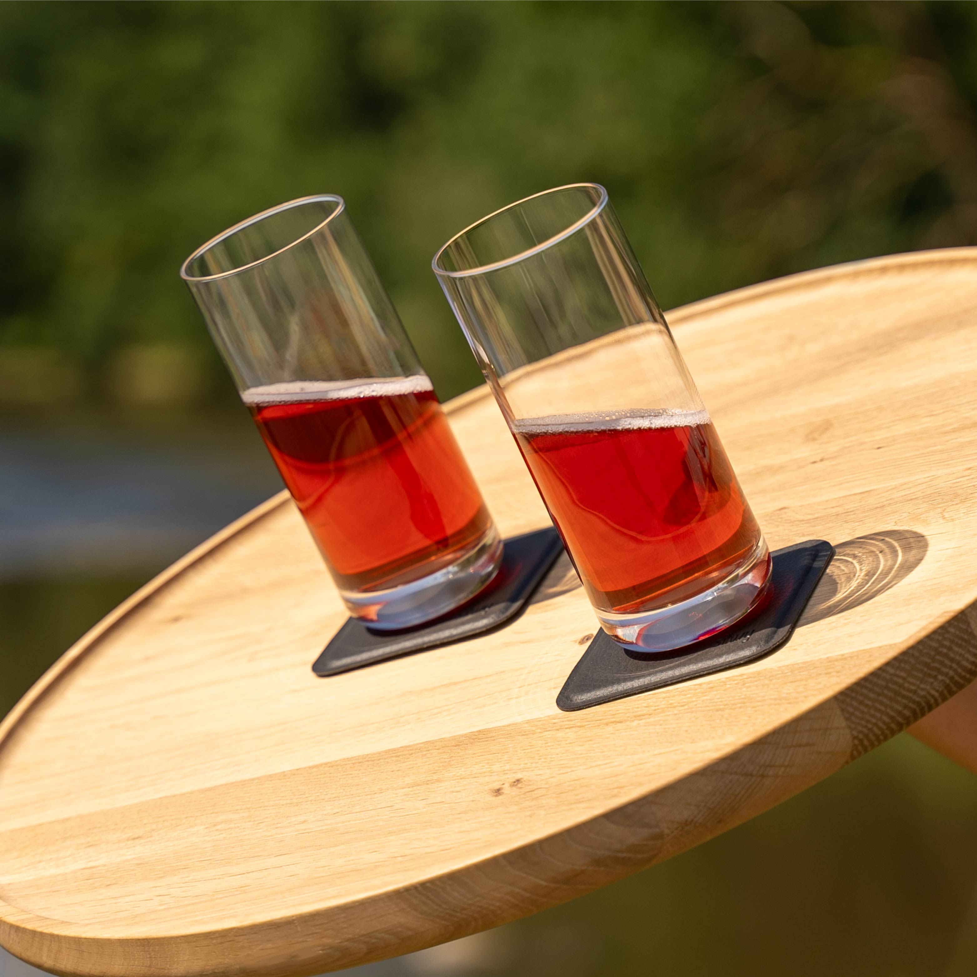 Magnet-Kristallgläser Longdrink slim auf pads abgestellt, schräg stehend auf einem Holztablett