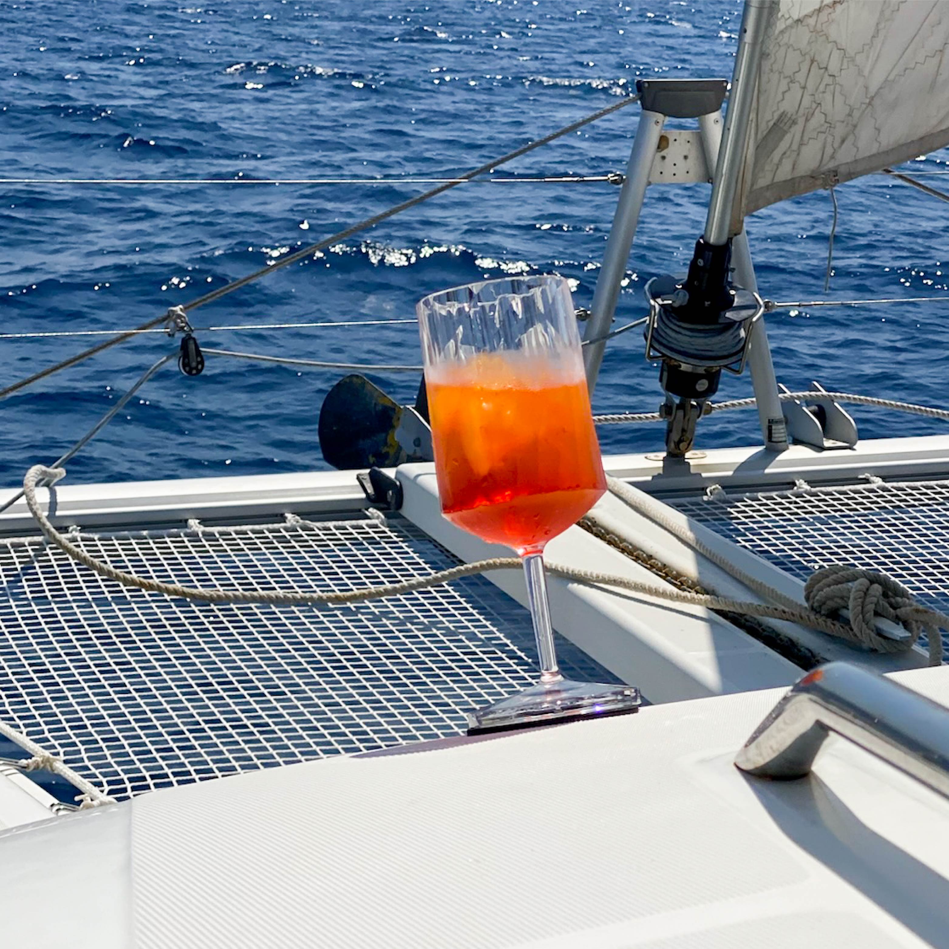Gefülltes Magnet-Kunststoffglas Wein auf einem Pad in Schräglage auf einem Boot