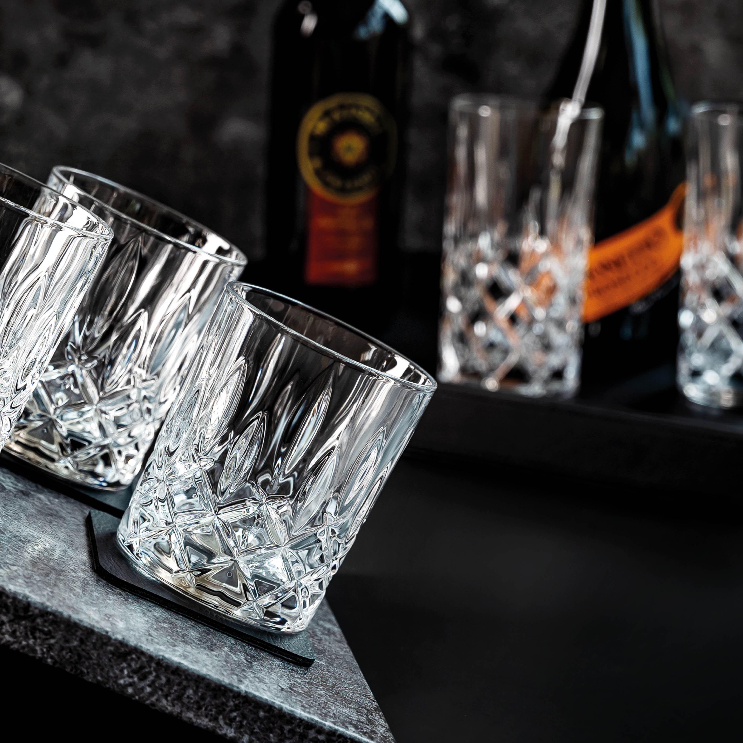 Magnet-Kristallgläser WHISKY auf schiefer Oberfläche mit dem quadratischen Metall-Nano-Gel-Pad, im Hintergrund 2 Magnet-Kristallgläser LONGDRINK auf einem Metall-Tablett